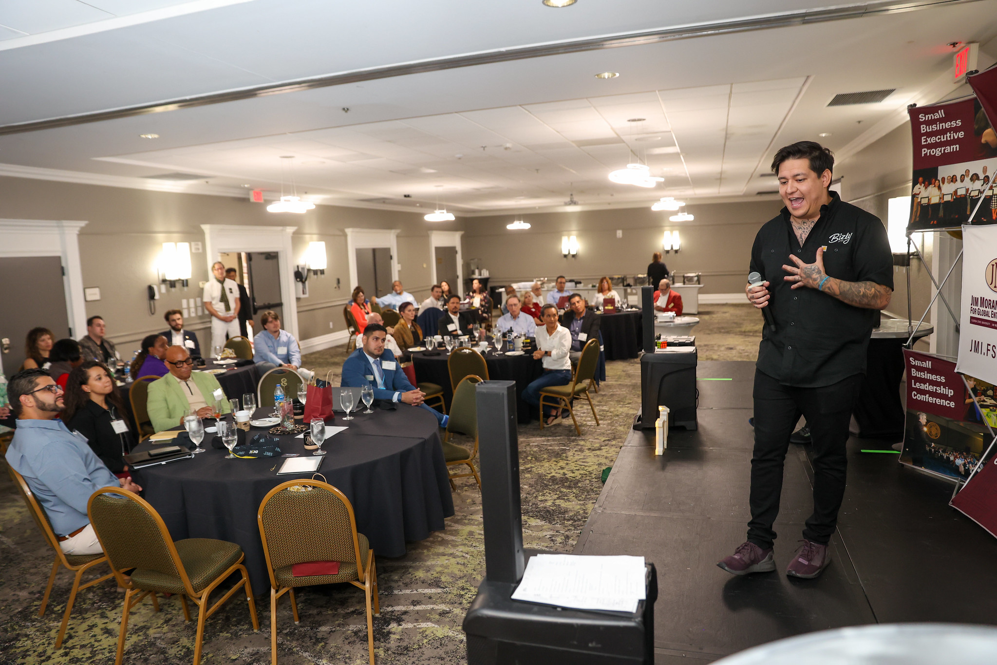 A speaker addresses a room full of seated attendees at the Jim Moran Institute's Small Business Leadership Conference